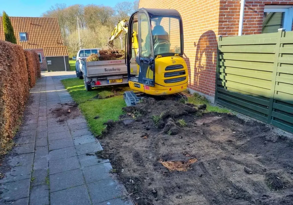 Området ved gavlen til nr. 15 bliver ryddet for græs og muld 19. april 2023